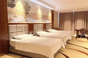 A hotel room with two beds, a mural, a dining table, and a curtain.