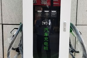 Una porta amb un senyal que indica una estació de càrrega per cotxes.