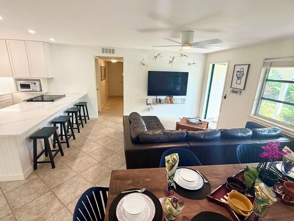 A modern living space with a kitchen, dining area, and seating area. - AVAILABLE NOW!! FERN COTTAGE! FREE beach parking! Weekly/Monthly/Yearly Rentals! (Naples)