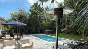 A backyard with a swimming pool, outdoor furniture, and a patio heater. - AVAILABLE NOW!! FERN COTTAGE! FREE beach parking! Weekly/Monthly/Yearly Rentals! (Naples)