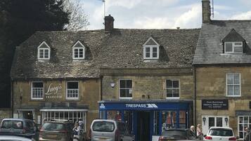 A row of stone buildings with multiple shops, including a tearoom and a furniture store.