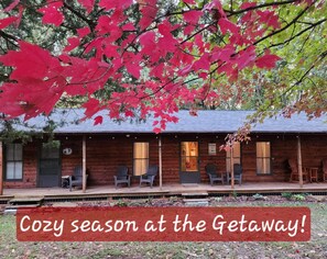 A cozy cabin-style building with a porch, wooden exterior, and a sign welcoming guests. - Secluded Cabin Getaway with Firepit (Greenfield)