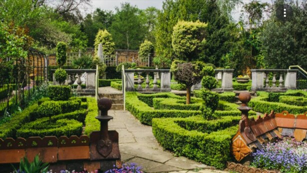 A formal garden with neatly trimmed hedges, stone pathways, and classical statues. - Livestay - 1bed Apt Private Building Free Parking (Luton)