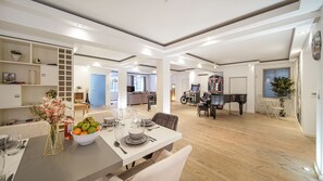 Enjoy meals together at the central dining table in this stylish living area, complete with a piano for entertainment.