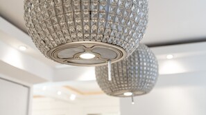 A contemporary chandelier hangs from the ceiling, its geometric pattern catching the light.