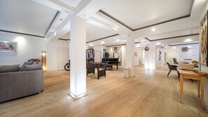 Relax in a spacious living area with a grand piano, dining space, and foosball table.