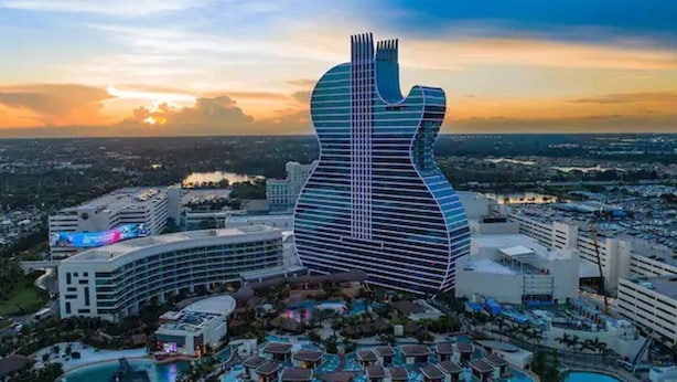A hotel with a guitar-shaped building, multiple swimming pools, and a resort area with overwater bungalows. - Renovated Home in Hollywood (Hollywood)
