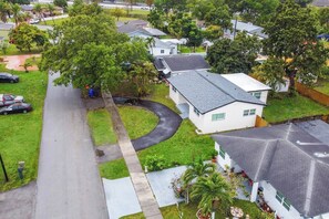 A residential area with houses, a curved driveway, and a lawn. - Pool Home, Sleeps 8, Hollywood Beach | Near Hard Rock, Monthly Stays Welcome (Hollywood)