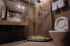 A modern bathroom with a glass-enclosed shower, a toilet, and a vanity with a mirror and sink. - Kaicheng Boutique Hostel (Poyang)