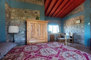 Una camera da letto con un letto, un armadio in legno, una scrivania con una sedia e una finestra.
