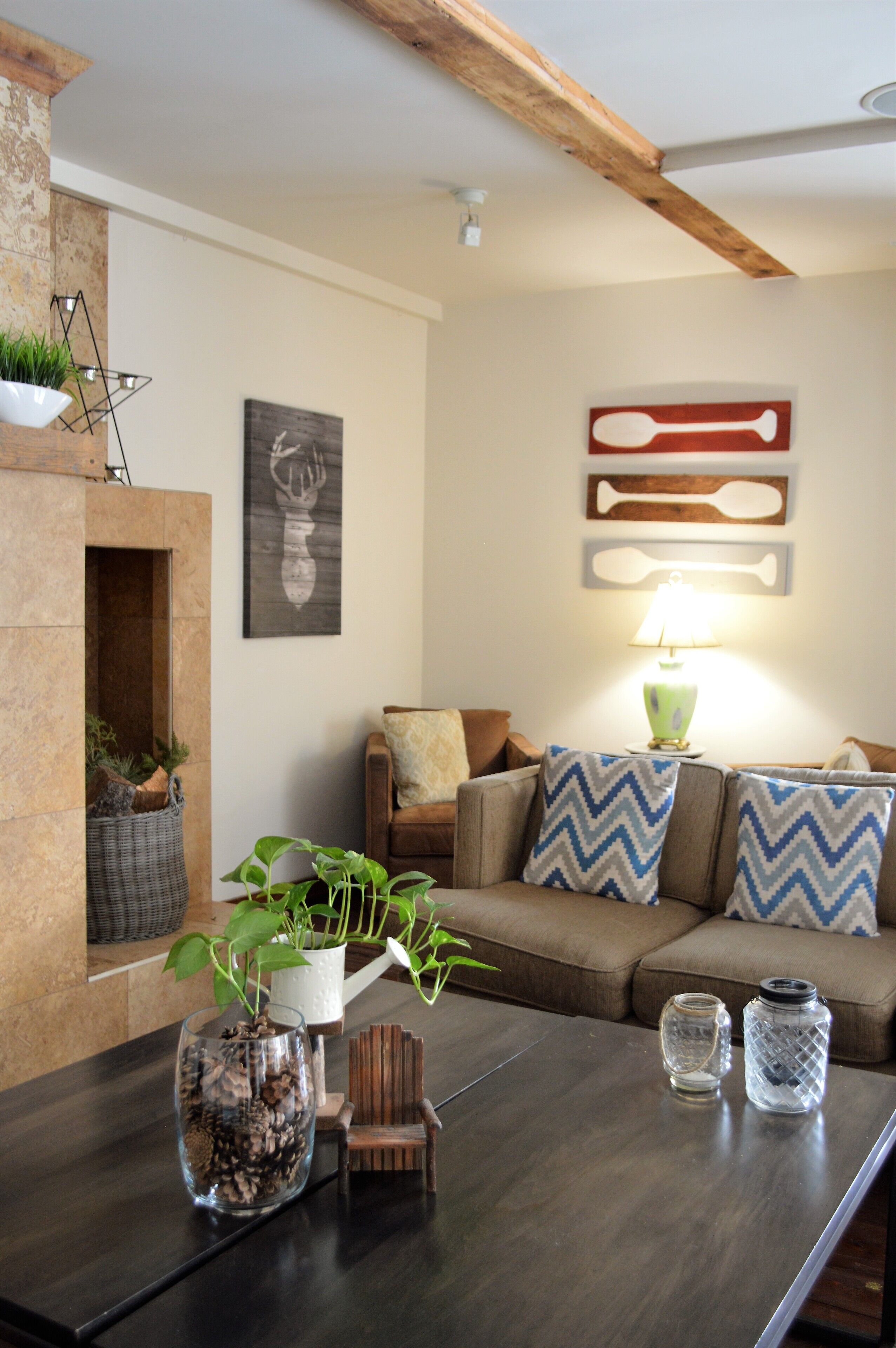 Una sala de estar acogedora con chimenea, un sofá con cojines estampados y una mesa de centro con adornos.