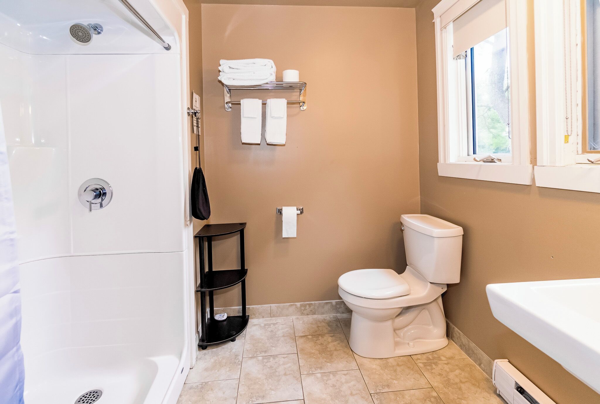 A bathroom with a shower, toilet, and bathtub.
