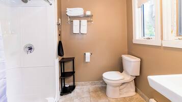 A bathroom with a shower, toilet, and bathtub.