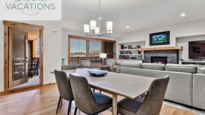 Una sala de estar moderna con comedor, chimenea y televisor.