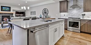 A modern kitchen with a central island, stainless steel appliances, and a fireplace.