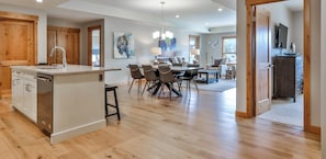 Una cocina amplia con una isla central, armarios de madera y un comedor con una mesa grande y sillas.