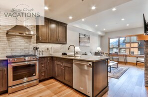 A modern kitchen with a built-in oven, stainless steel dishwasher, and wooden cabinets.