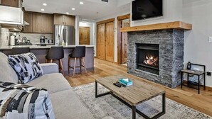 Una sala de estar moderna con chimenea de piedra, un sofá y una mesa de centro.