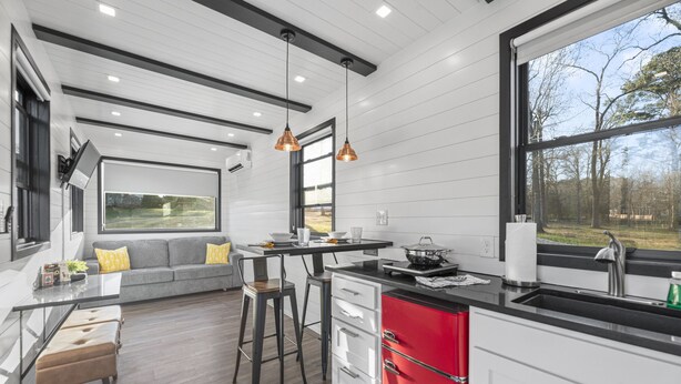 A modern kitchen with a dining area, large windows, and a view of the outdoors. - Brine Time: 2 mins to Lake Conroe! Heated Pool, Fire Pit, Stocked Ponds (Willis)