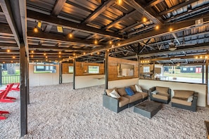 Relax in this cozy space with a sofa, armchairs, and large windows offering views of the outdoors.