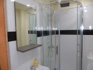 Appartement | Badkamer | Een douche, een haardroger, handdoeken