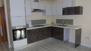 Une cuisine moderne avec des meubles blancs, une cuisinière et un évier.