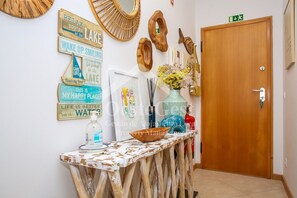A hallway with rustic decor, including wooden signs and a wooden table with a vase and a bowl.