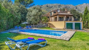 A pool with lounge chairs, a stone pathway, and a house with a stone facade and green shutters. - Samoter, Finca 5EstrellasHome Mallorca (Cala San Vicente)