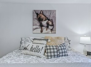 A bedroom with a bed, pillows, a painting, and a bedside lamp. - Vermont Retreat (Bridgewater)