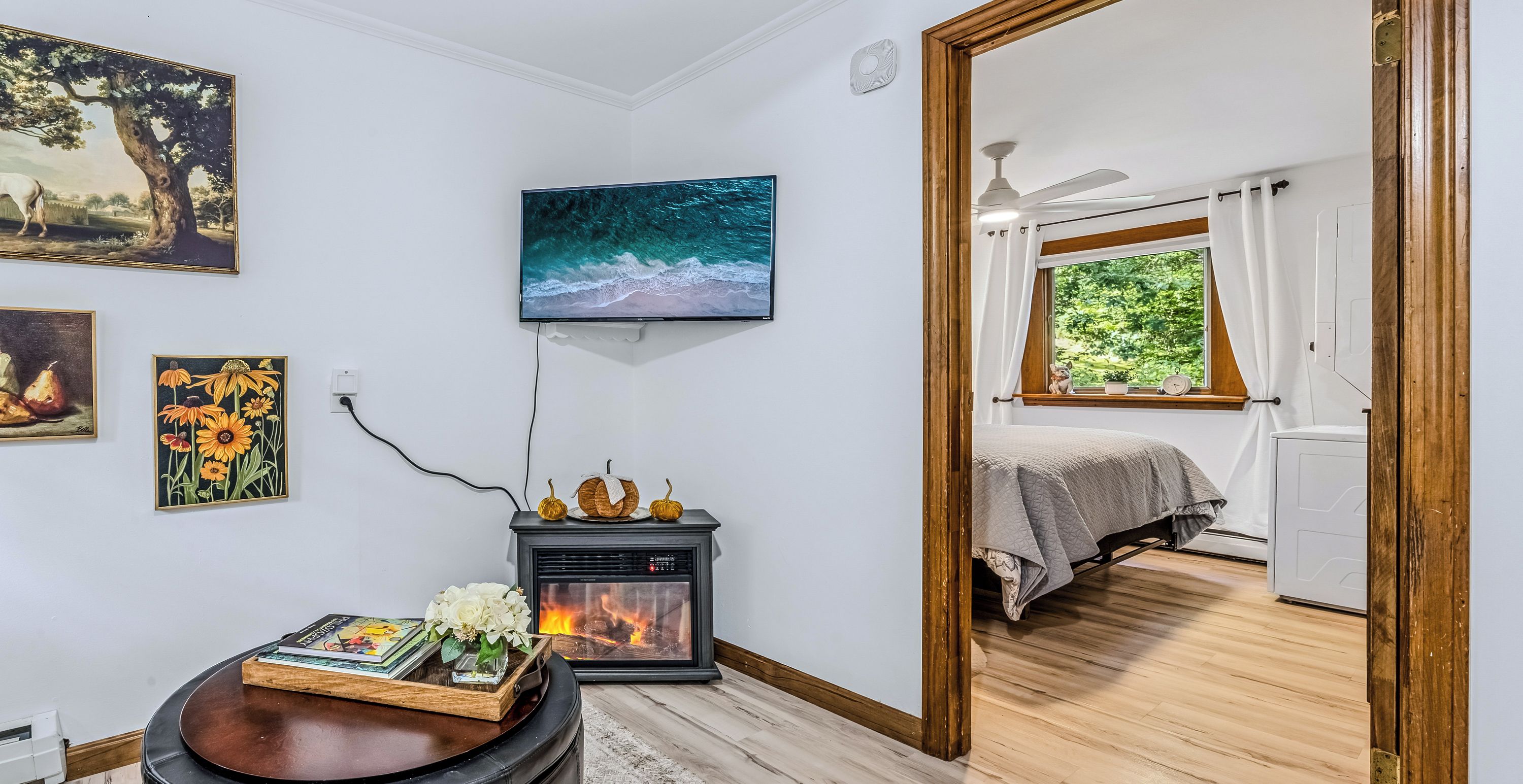 A room with a fireplace, a television, and artwork on the walls.