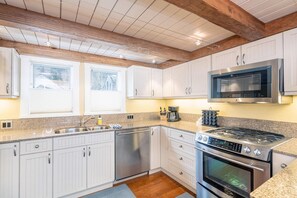 A kitchen with white cabinets, a stainless steel dishwasher, a gas stove, and a microwave. - Columbine E 1 Bedroom with Loft (Telluride)