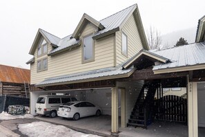 A two-story house with a garage, a van, and a car parked outside. - Columbine E 1 Bedroom with Loft (Telluride)