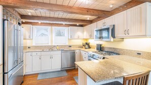 A modern kitchen with white cabinets, stainless steel appliances, and a granite countertop. - Charming Downtown Telluride Retreat | Walk to Main Street, Gondola & Lift 7 (Telluride)