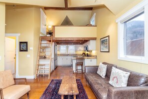 A cozy interior with a loft bedroom, a dining area, and a kitchen. - Columbine E 1 Bedroom with Loft (Telluride)