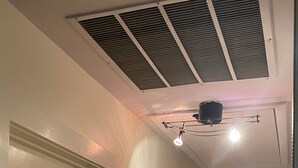 A hallway with a ceiling vent, a door with a brass handle, and a wall-mounted light fixture. - Cute, cozy rancher close to down town Annapolis (Annapolis)