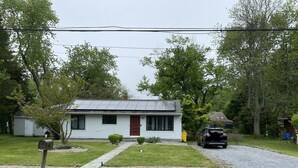 A single-story house with a red door, a small front yard, and a gravel driveway. - Cute, cozy rancher close to down town Annapolis (Annapolis)