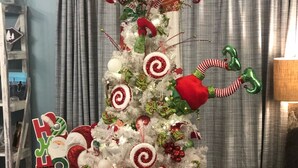 Een versierde kerstboom met decoraties en een kerstmanbeeldje.