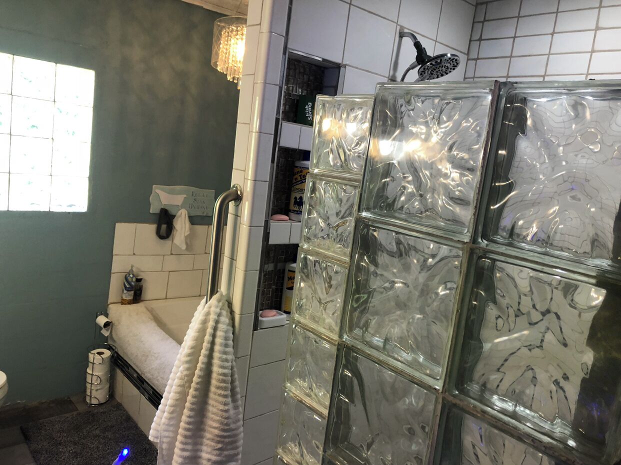 Un baño con cabina de ducha de vidrio, inodoro, lavamanos y toallero.
