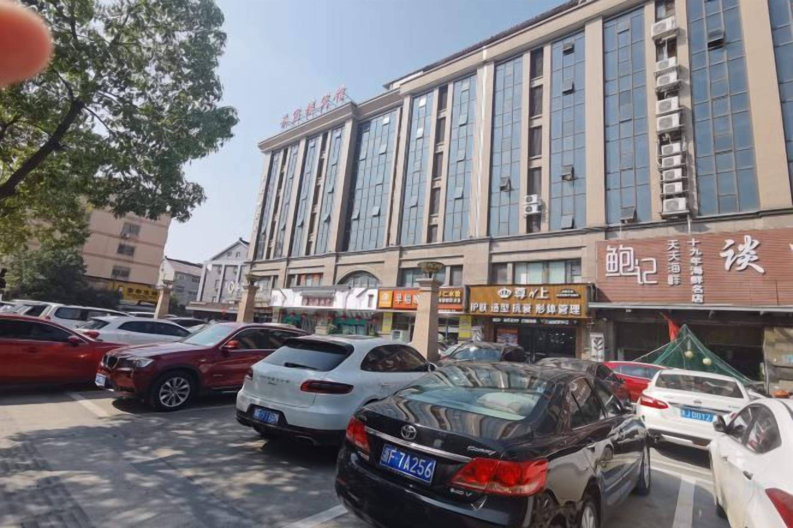 Un edificio de varios pisos con una hilera de comercios en la planta baja.