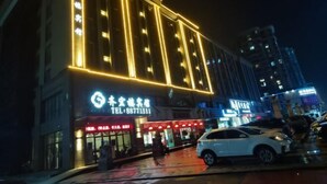 A hotel with illuminated signage and a visible entrance. - Puyuan Qihonglou Hotel (Tongxiang)