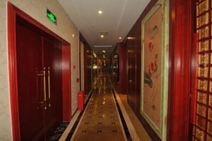 A hotel corridor with red doors, a marble floor, and a wall with a floral painting. - Chongzhou Lanfeng Hotel (Chongzhou)