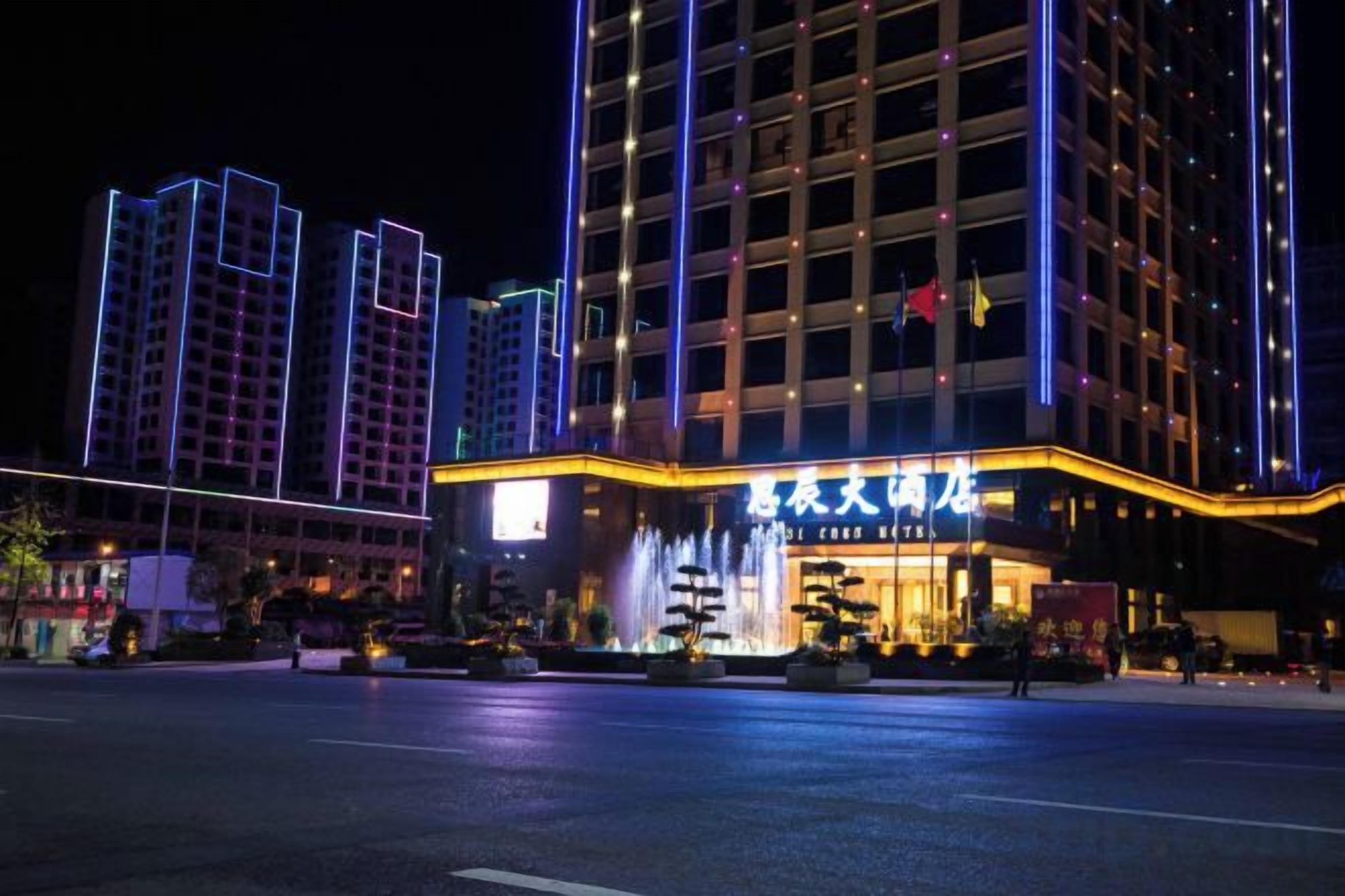A hotel with a prominent entrance, multiple floors, and a well-lit facade.