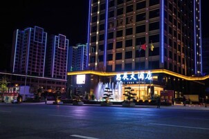 Un hotel con una entrada destacada, varios pisos y una fachada bien iluminada.
