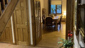 A staircase leading to a dining area with a view of the outdoors. - Foxglove Cottages (Drymen)