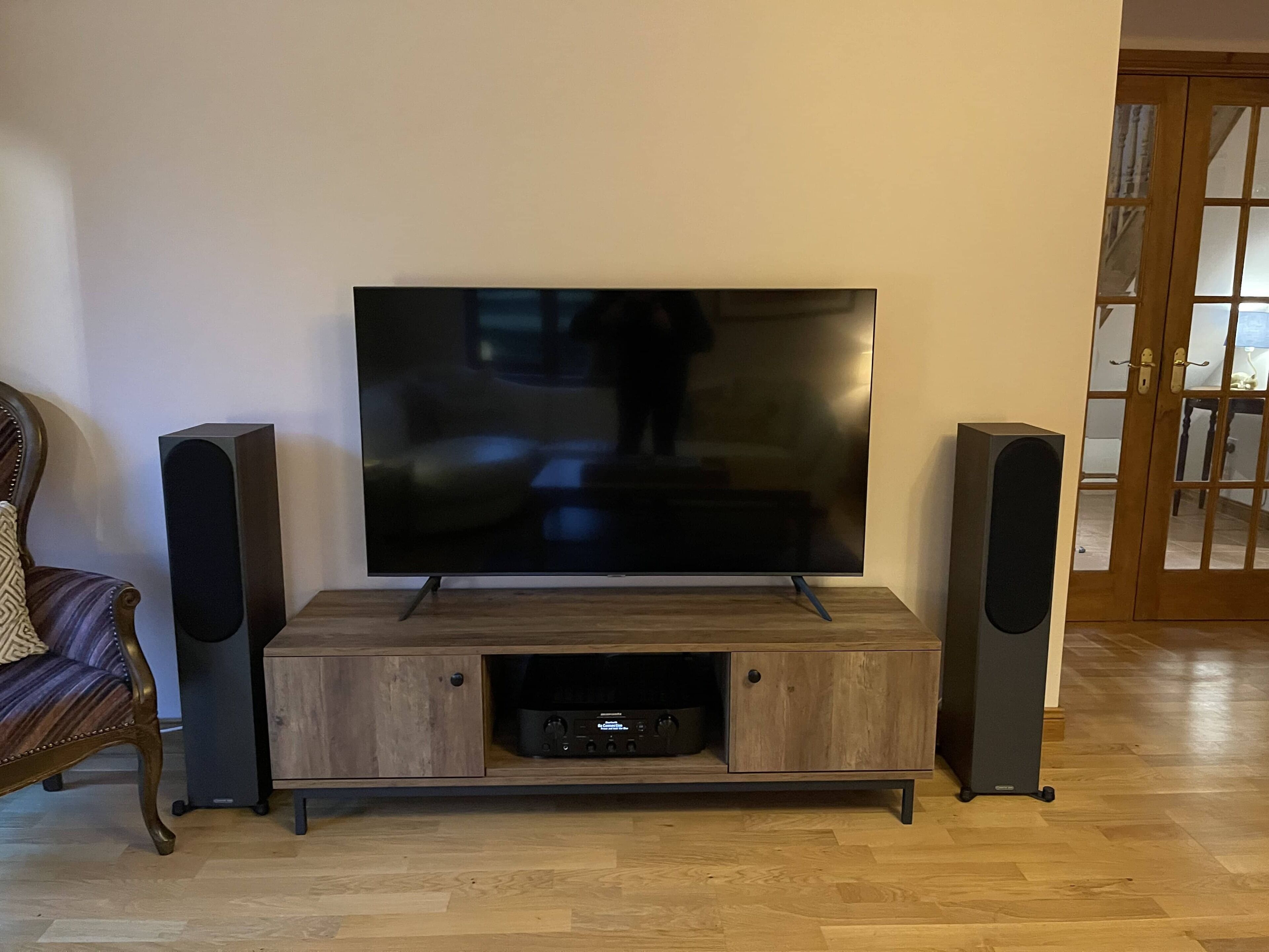 A flat-screen TV on a wooden stand with two speakers on either side.