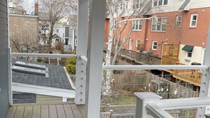 A covered wooden deck with a view of neighboring houses and a fenced yard. - Entire condo center of downtown Newburyport (Newburyport)