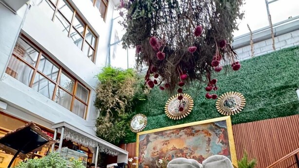 A modern indoor atrium with a high ceiling, large windows, and a central hanging floral arrangement. - Intiwatana Hotel Boutique (Cusco)