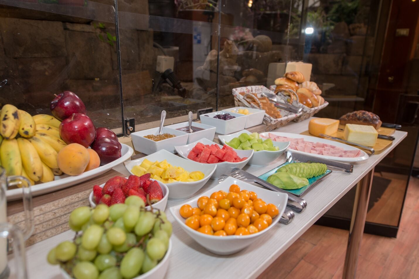 A buffet table with various fruits, vegetables, and cheeses.