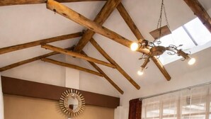 A bedroom with a large bed, wooden beams, a skylight, and a view of a staircase. - Intiwatana Hotel Boutique (Cusco)