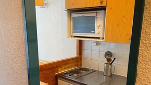 A compact kitchen with a microwave, stove, and sink. - Studio terrace with beautiful view and direct access to all hiking trails; sleeps 4 (Modane)
